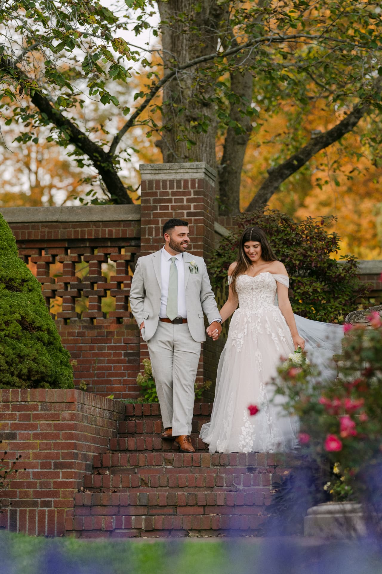 Couple walking down brick garden steps in autumn